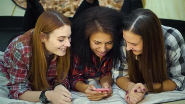 Lovely girls lying in tent with smartphone and browsing social media — 图库视频影像