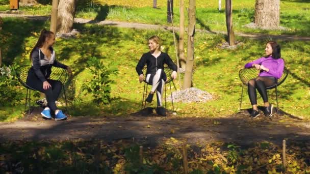 Multiracial friends in sportswear having rest in public park — Stock video