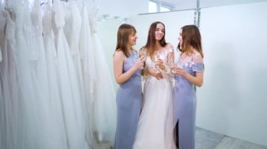 Bride and bridesmaids celebrating upcoming event with wine in wedding salon