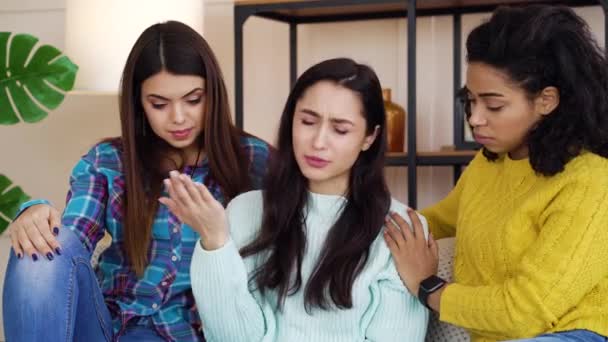 Amigos femininos sentados perto e apoiando companheiro de quarto deprimido em casa — Vídeo de Stock