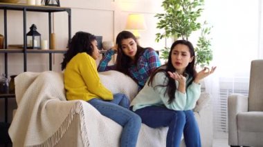 Hateful girls sitting in living room and gossiping about their roommate