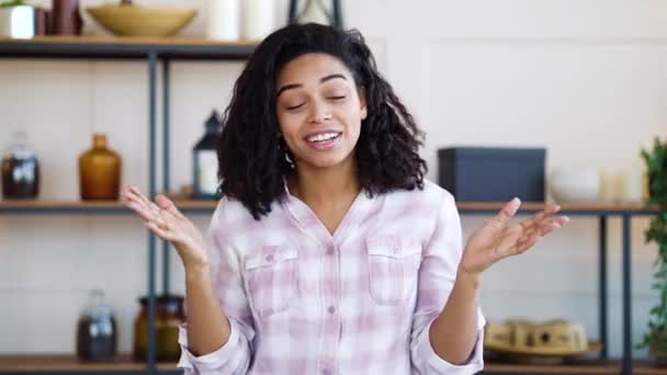 Confused black girl gesturing with hands in living room — Stock Video