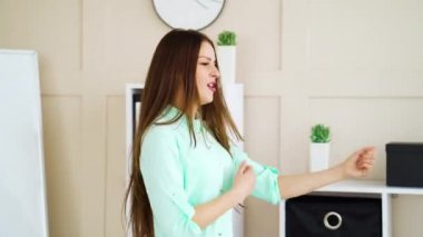 Mola sırasında ofiste dans eden mutlu iş kadını.