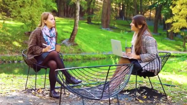 Жінки-фрілансери, що працюють в осінньому парку — стокове відео