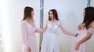 Güzel gelin ve nedimeler kuaförde düğün için elbise deniyorlar.