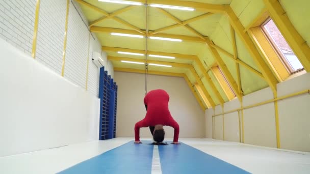 Athletic girl making somersault on soft mats in gym — 비디오