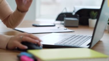 Young female hands with manicure typing on laptop in office
