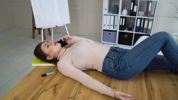 Pretty girl lying on office table and talking on phone — Stock videók