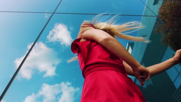 Lage hoek van aantrekkelijke vrouwelijke danser in rode jurk tegen spiegel oppervlak — Stockvideo