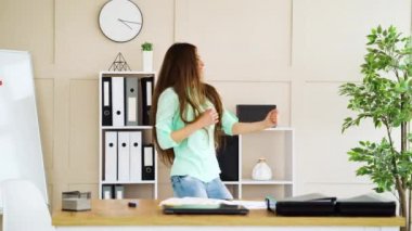 İş yerinde dans eden mutlu iş kadını.