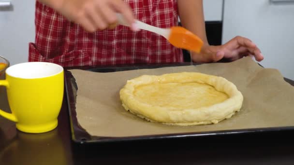 Female hands applying egg grease on raw dough — ストック動画