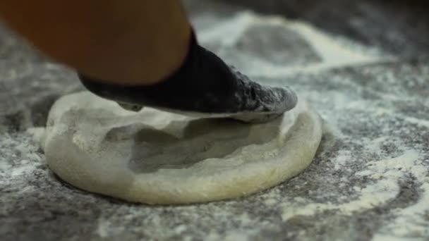 Manos en guantes amasando masa cruda en la superficie con harina de primer plano — Vídeos de Stock