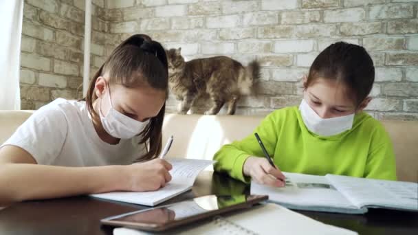 Orvosi maszkos lányok karanténban maradnak és házi feladatot csinálnak. — Stock videók