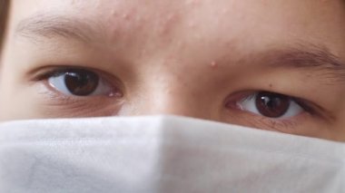 Tıbbi maske takan bir gencin makro görüntüleri.