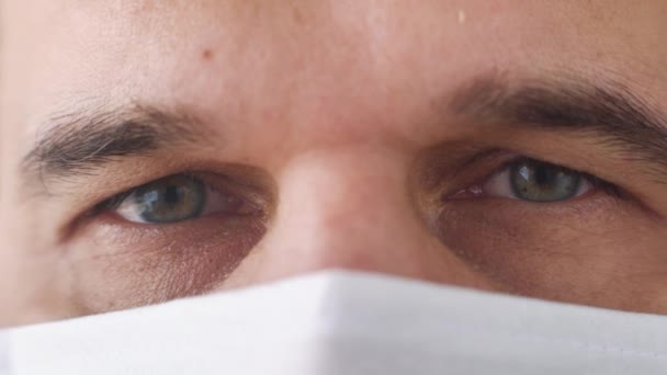 Images macro des yeux d'un médecin fatigué portant un masque médical — Video