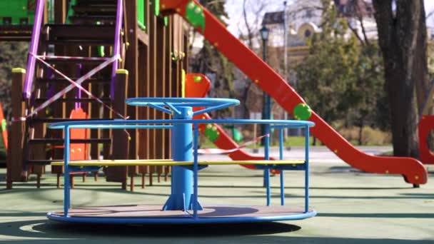 Abandoned carousel and slides with restriction tape on empty playground — Stock Video