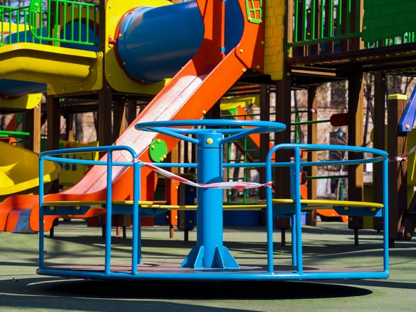 Pequeno carrossel com fita de restrição no parque infantil vazio durante o coronavírus — Fotografia de Stock