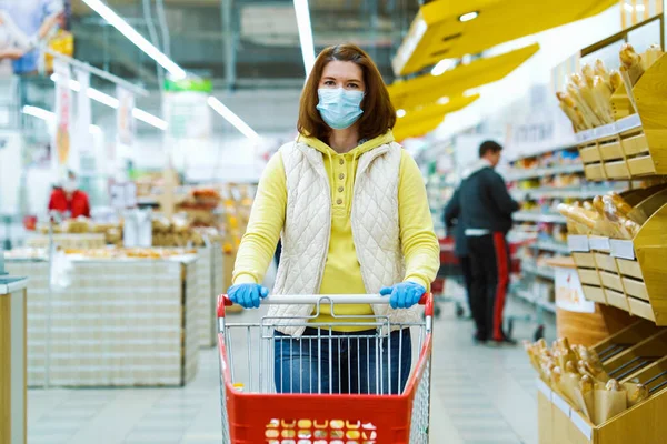 Manavda maske takan kız salgın sırasında alışveriş arabasıyla dikiliyor.