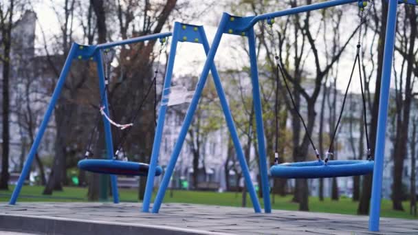 Swings ταλαντεύεται σε άδειο παιδική χαρά κατά τη διάρκεια πανδημίας COVID — Αρχείο Βίντεο