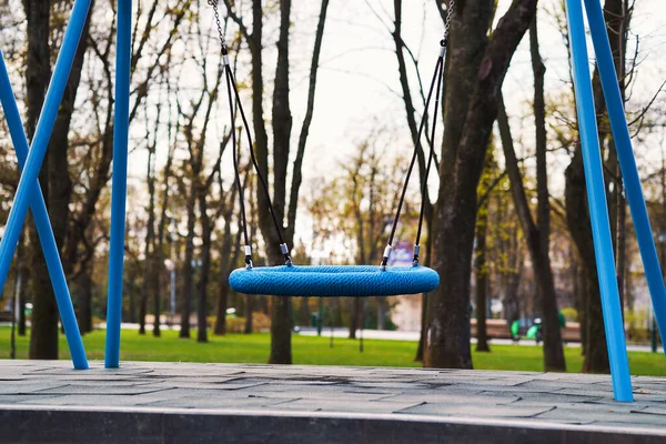 Balanços balançando no playground vazio durante a pandemia de COVID — Fotografia de Stock