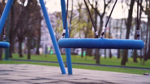 Blauwe schommels op lege speelplaats tijdens COVID-19 pandemie — Stockvideo
