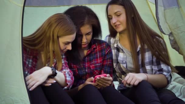 Meninas jovens usando smartphone na tenda turística no parque de campismo — Vídeo de Stock