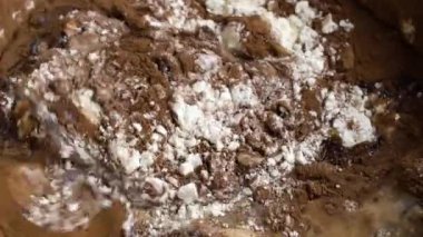 Çikolatalı keklerin malzemelerini karıştıran kadın eli.