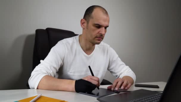 Графический дизайнер с помощью планшета и ноутбука работает из дома на карантине — стоковое видео