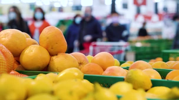 Vers fruit en klanten met medisch masker in de supermarkt tijdens de pandemie — Stockvideo