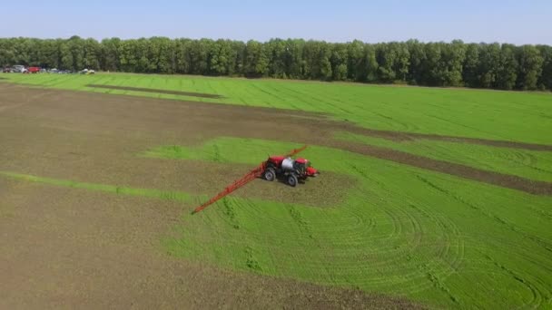 Обприскування трактора їзда на зеленому полі в сільській місцевості — стокове відео