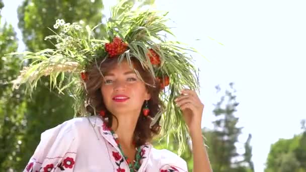 Mooi vrouwelijk model in bloemencirkel en geborduurde jurk poseren buiten — Stockvideo