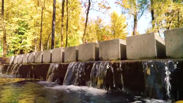 Modern bridge with waterfall crossed by female joggers — Stock Video