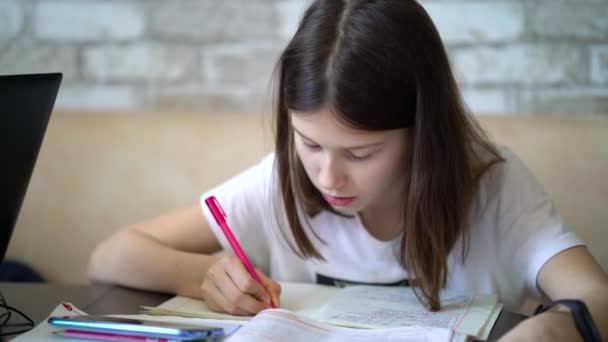 Chica haciendo la tarea y escribiendo en el cuaderno — Vídeos de Stock