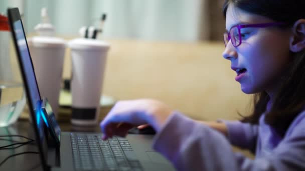 Gözlüklü akıllı kız evde ders çalışmak için dizüstü bilgisayar kullanıyor. — Stok video