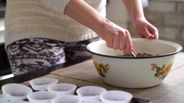 Mujer de la cosecha revolviendo masa cruda para cupcakes de chocolate en la cocina — Vídeos de Stock