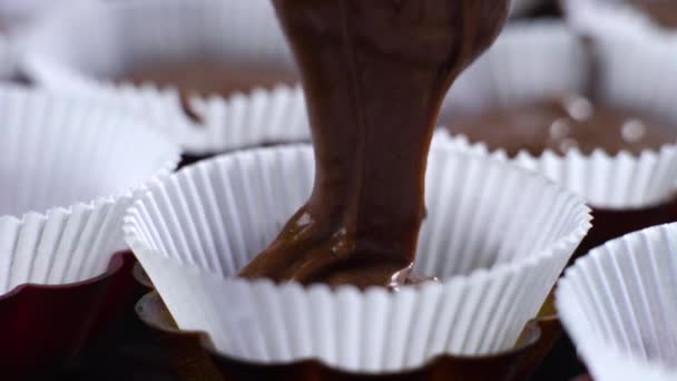 Kek formlarını dolduran çiğ çikolata hamuru. — Stok video