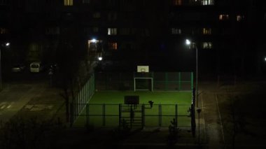 Geceleri gökdelenlerin önünde futbol oynayan insanların zamanlaması