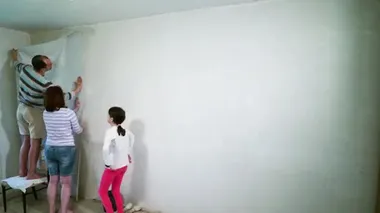 Zaman ayarlı aile oturma odasında duvar kağıtlarını yapıştırıyor