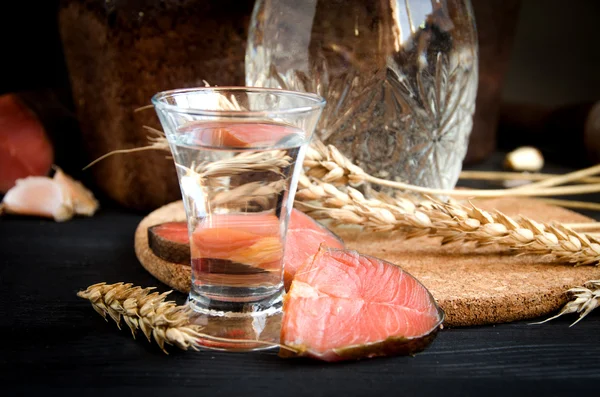 Vodka glass decanter wheat salmon garlic closeup — Stock Photo, Image