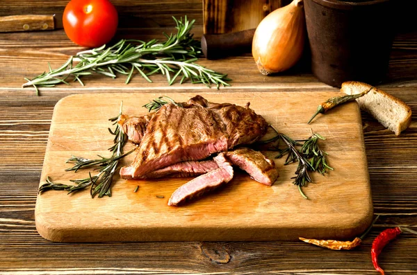 Rare steak rectangular wooden cutting board spices — Stock Photo, Image