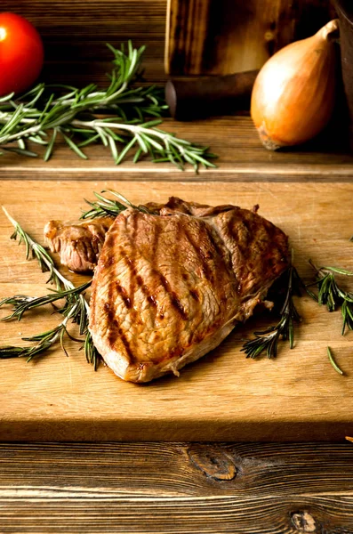 Grilled steak rosemary sliced wooden cutting board spices — Stock Photo, Image