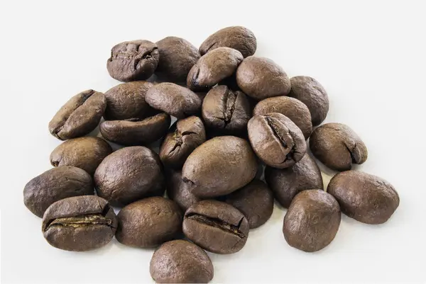 Coffee beans in macro over white background — Stock Photo, Image