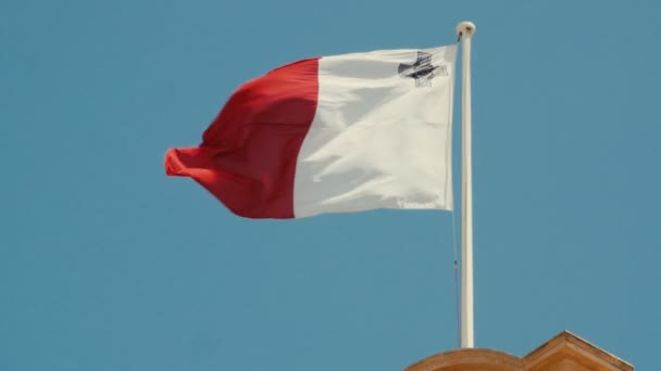 Drapeau de Malte devant le ciel bleu flottant sur le mât du drapeau. Images 4K . — Video