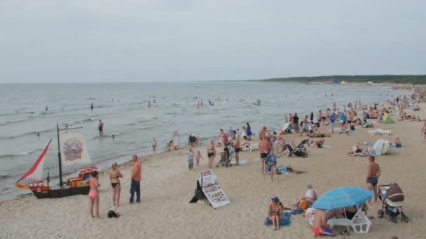 リトアニア、リトアニア - 2016 年 7 月 30 日: 人々 リラックスや日光浴、暑い夏の日の間にパランガ市ビーチで泳ぎ. — ストック動画