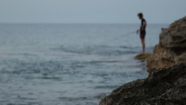 Pescador al atardecer. silueta de un pescador con caña de pescar . — Vídeos de Stock