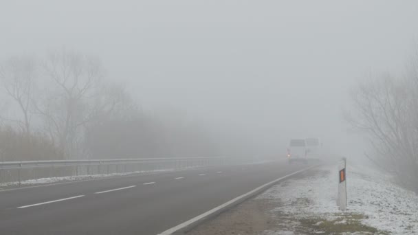 Cars ride on the road and shining lights in the fog — Stock Video