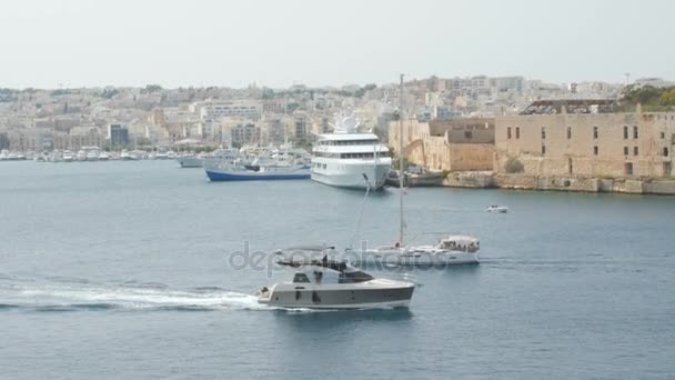 Barco, iate navega no fundo da cidade Valletta em Malta. Tiro largo, no fundo de casas recém-construídas . — Vídeo de Stock