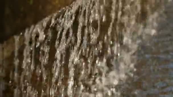 Nahaufnahme des tropfenden Wassers im Sonnenlicht. — Stockvideo