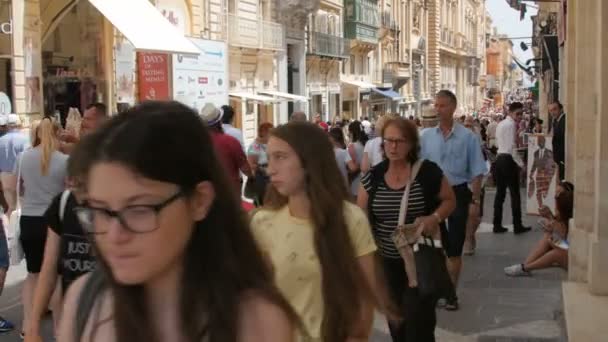 Malta hauptstadt valletta stadtzentrum, fußgängerzone - juli 2016: viele touristen und ortsansässige einkaufen in der alten stadt voller geschäfte, cafés, apotheke kinder spielen, freunde plaudern — Stockvideo