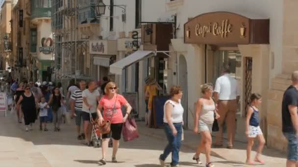 몰타의 수도 발레 타 시 센터, 보행자 거리-7 월 2016: 많은 관광 및 쇼핑 상점, 카페, 약국 아이 재생, 채팅 친구의 오래 된 시내 전체에서 현지 사람들 — 비디오